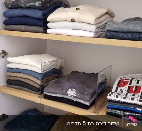 בגדים מקופלים בארון עץ עם מדפים